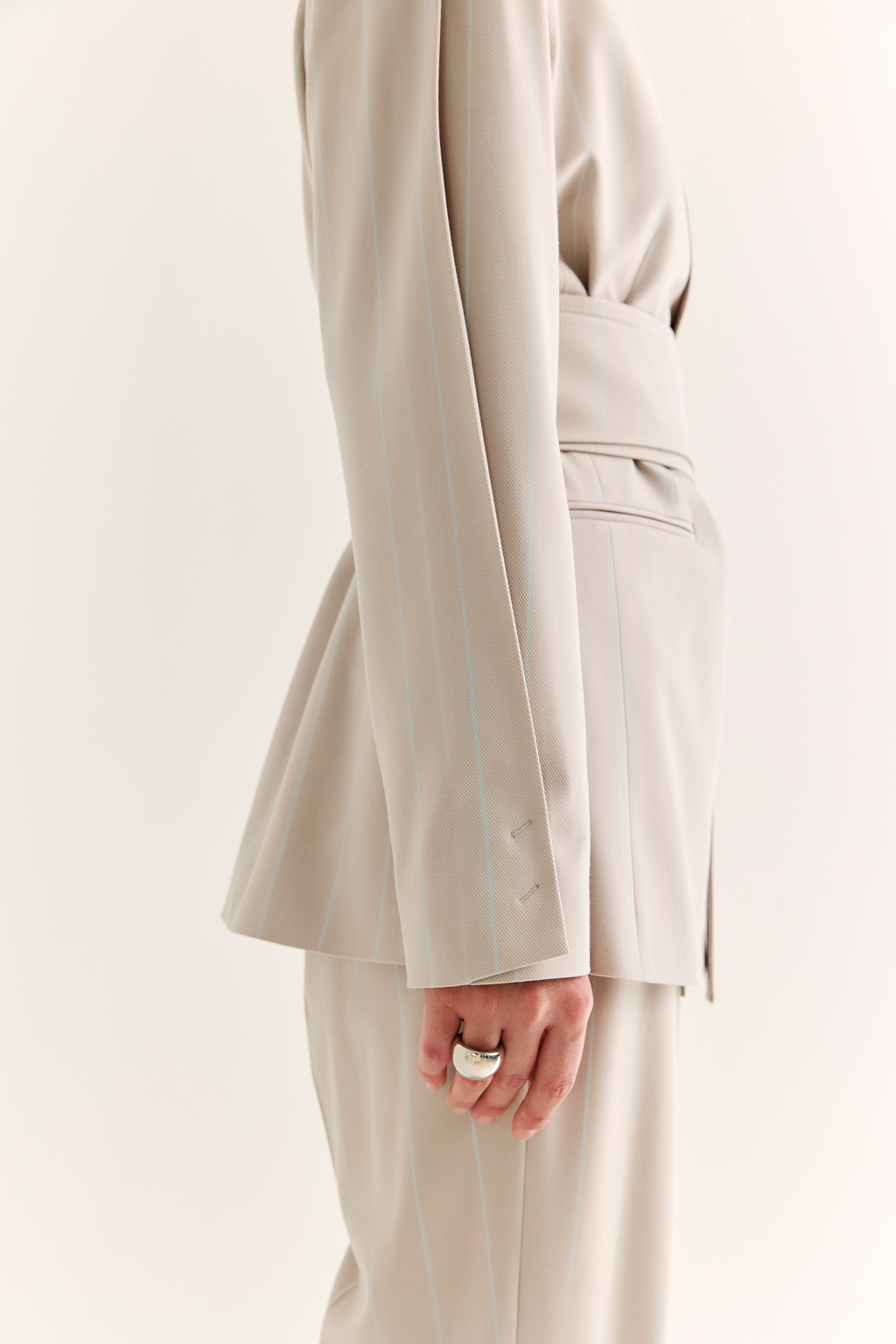 Жакет с поясом-кушаком: мягкая сила и подчёркнутая линия. Этот жакет сочетает в себе структурированную форму и пластичность драпировки. Приталенный силуэт акцентирован широким поясом-кушаком, который завязывается на талии, формируя выразительную линию «песочных часов» и добавляя образу женственности без излишней строгости.
Острые лацканы, аккуратная линия плеч и выверенный крой рукавов делают модель универсальной: для делового дня, кэжуал-комплекта или вечернего выхода. Пояс, завязанный на узел или бант, задаёт настроение и подчеркивает индивидуальность. Гармония формы и мягкости. Жакет, который раскрывает силу через утончённость.