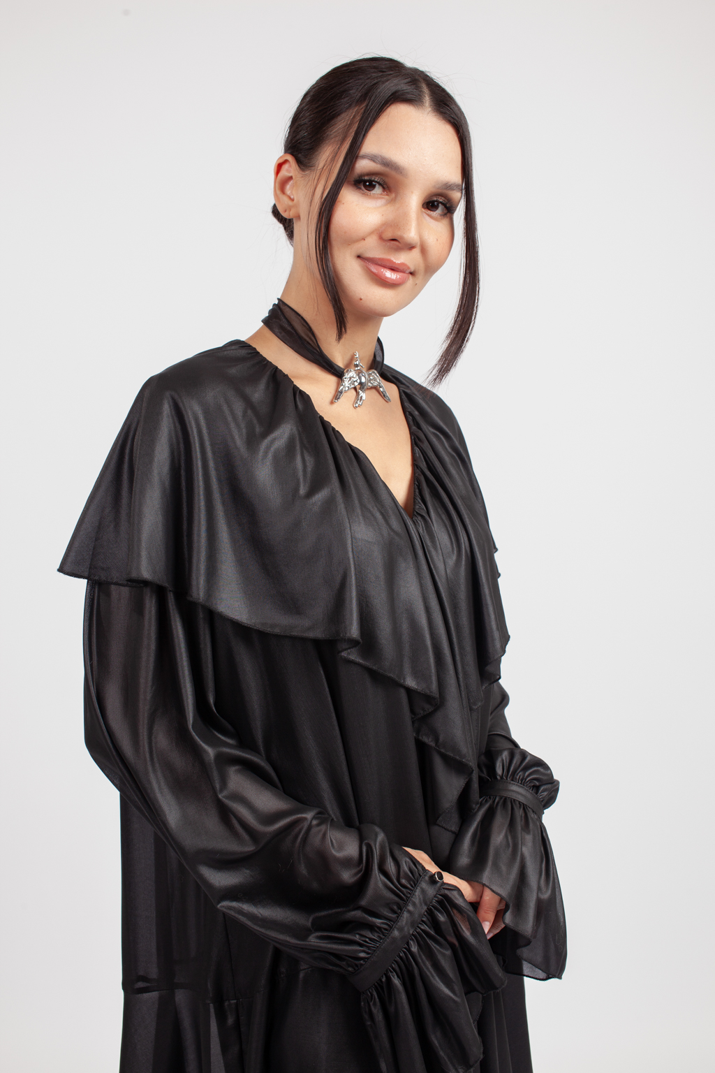 Дизайнерское колье из коллекции «SERENITY» с металлическим кулоном в виде летящей птицы серебряного цвета на текстильной ленте из черной плотной органзы. Длина ленты позволяет варьировать стиль колье. Украшение выполнено из гипоаллергенного сплава с гальваническим покрытием. Колье прекрасно сочетается как с платьями, так и с жакетами.  Вес колье составляет 39 гр, длина до 140 см.