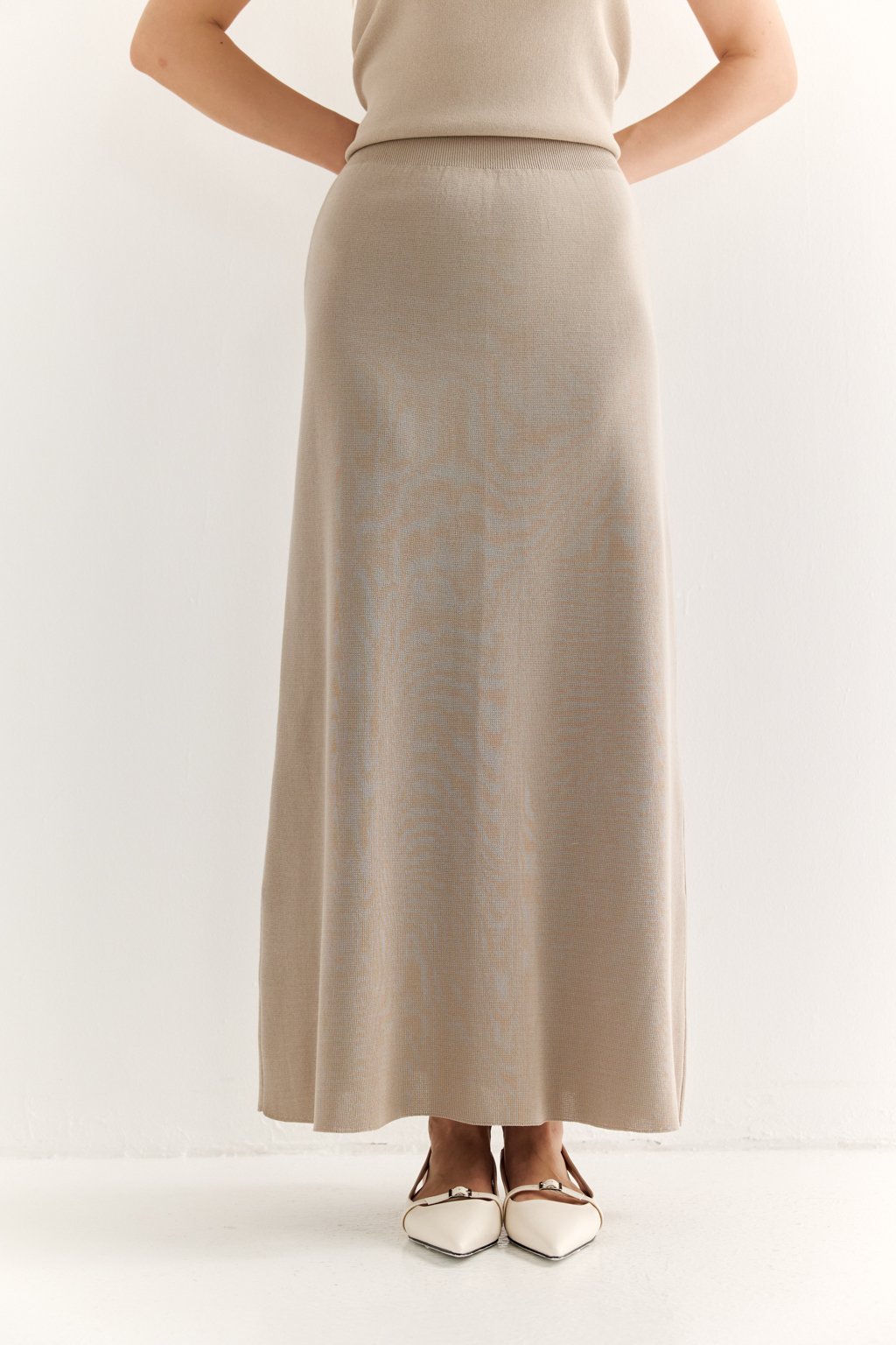 Юбка силуэта трапеции длиной миди.