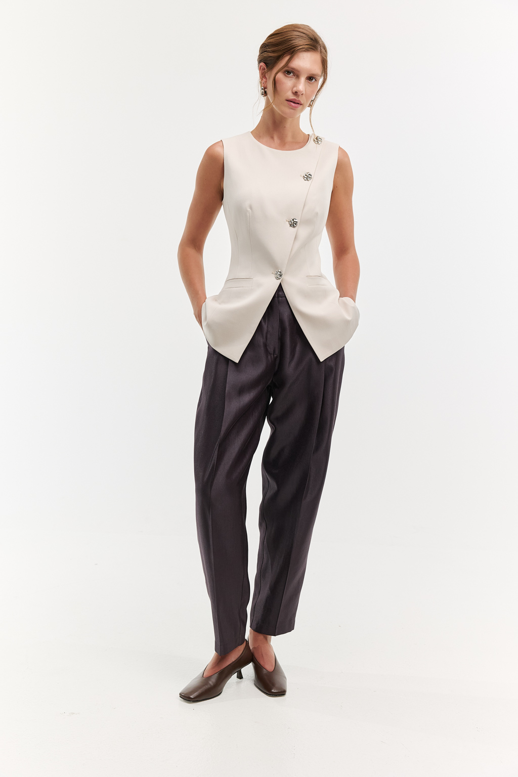 Жилет приталенного силуэта с асимметричным бортом и застежкой на декоративные пуговицы. Идеальный выбор для особых событий. Асимметричный дизайн и пуговицы делают модель уникальной. Комфортное сочетание шерсти, шёлка и вискозы обеспечивают идеальную посадку и сохраняют тепло и уют. Преимущества ткани: сочетание шерсти и шёлка создает премиальный эффект и уникальные тактильное ощущения. Материал держит форму, устойчив к износу. Гладкая поверхность выглядит дорого и изысканно. Жилет может стать предметом как первого слоя одежды, так и в второго.