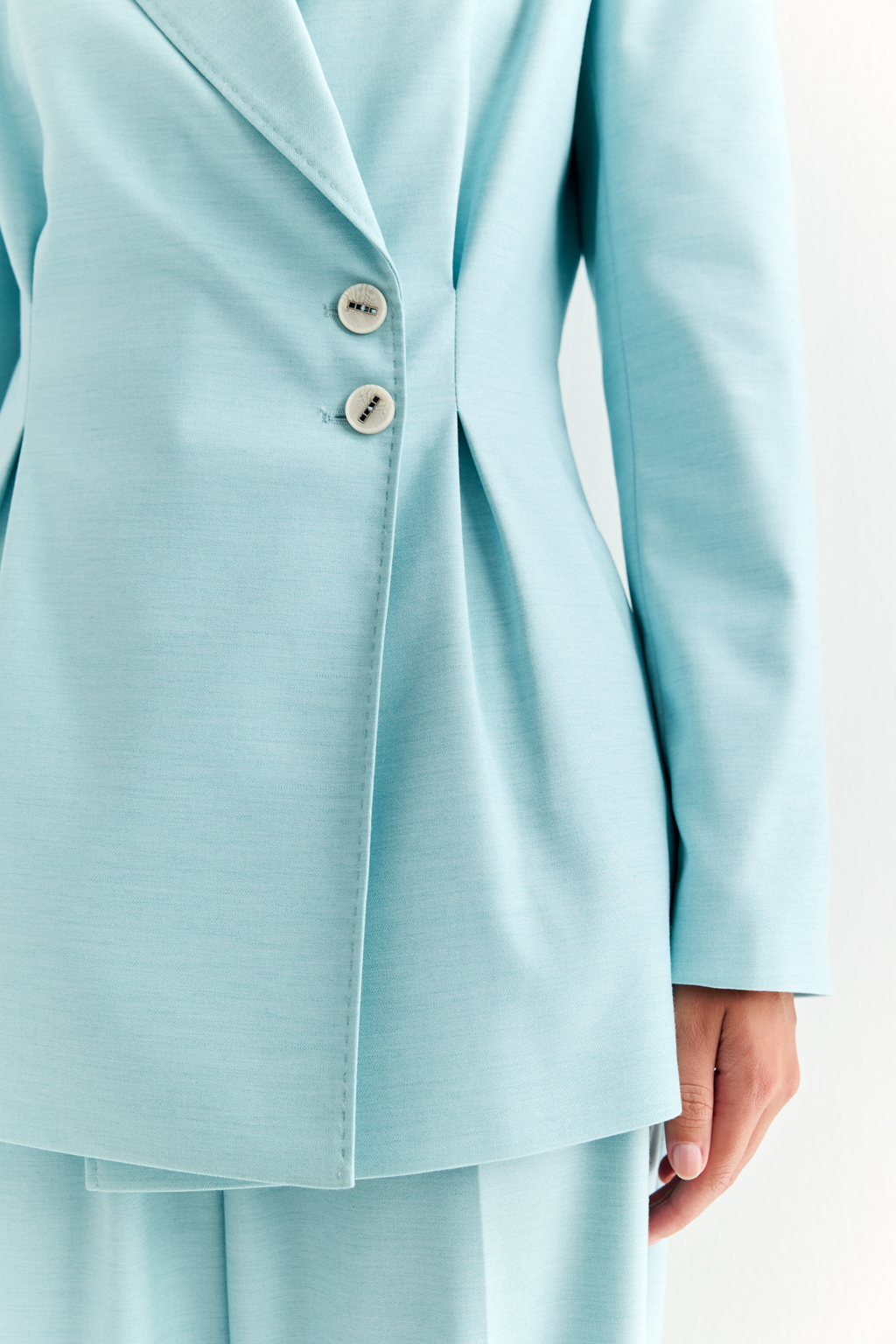 Приталенный жакет: акцент на силуэт и уверенность. Классический жакет со смещённой застёжкой и декоративными складками, подчёркивающими талию, — это вещь, которая формирует образ с первого взгляда. Чёткие линии плеч, заострённые лацканы и приталенный крой создают силуэт, говорящий о силе, вкусе и уверенности. Асимметричная застёжка добавляет изящную детализацию, а универсальная длина делает модель уместной как в деловом комплекте, так и в стилизациях с джинсами или платьями. Идеально садится и подчёркивает фигуру. Современная классика для женщины, которая знает, чего хочет.