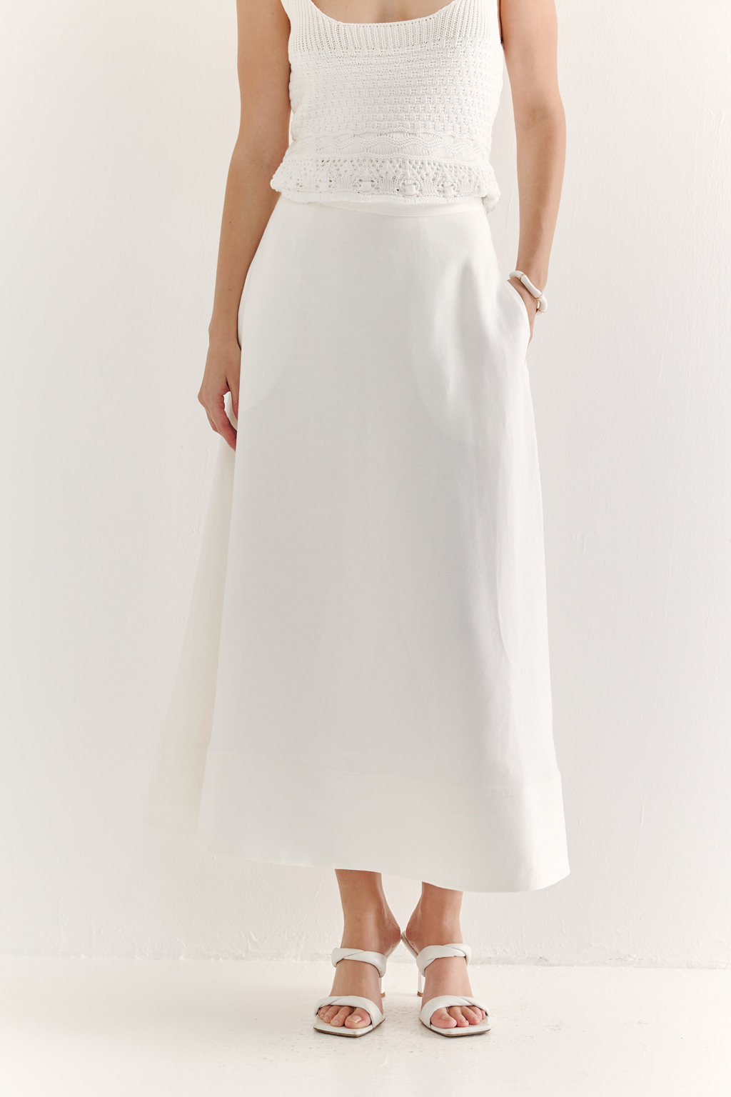 Юбка-миди, с силуэтом полусолнце, из уникальной ткани – 100% льняного твила белого цвета с эффектом air wash, является must-have наступающего сезона. Расширяющийся книзу силуэт дополнен притачным бордюром по нижнему краю, что подчеркивает женственность образа. Юбка имеет подкладку, узкий пояс и застежку на потайную молнию в боковом шве. Предлагаем носить эту юбку с льняными жакетами, а так же вязанными трикотажными топами.