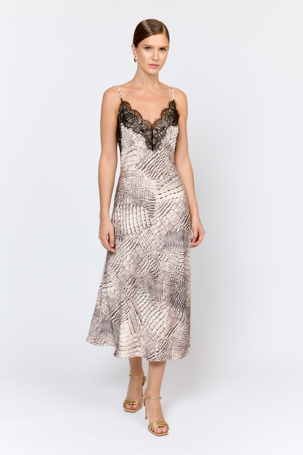 Платье-комбинация, скроенное по косой, на тонких бретелях и отделанное декоративным кружевом по верхней части. Длина платья  мидакси. Идеально для женственных образов для особых случаев и повседневной жизни в сочетании с базовыми жакетами, свитерами и кардиганами. Лаконичный крой,  подчеркивающий силуэт, обрамленная кружевом линия декольте делают образ соблазнительным и актуальным. Цветовое сочетание в дизайне принта позволяет легко  комбинировать изделие с другими моделями коллекции.