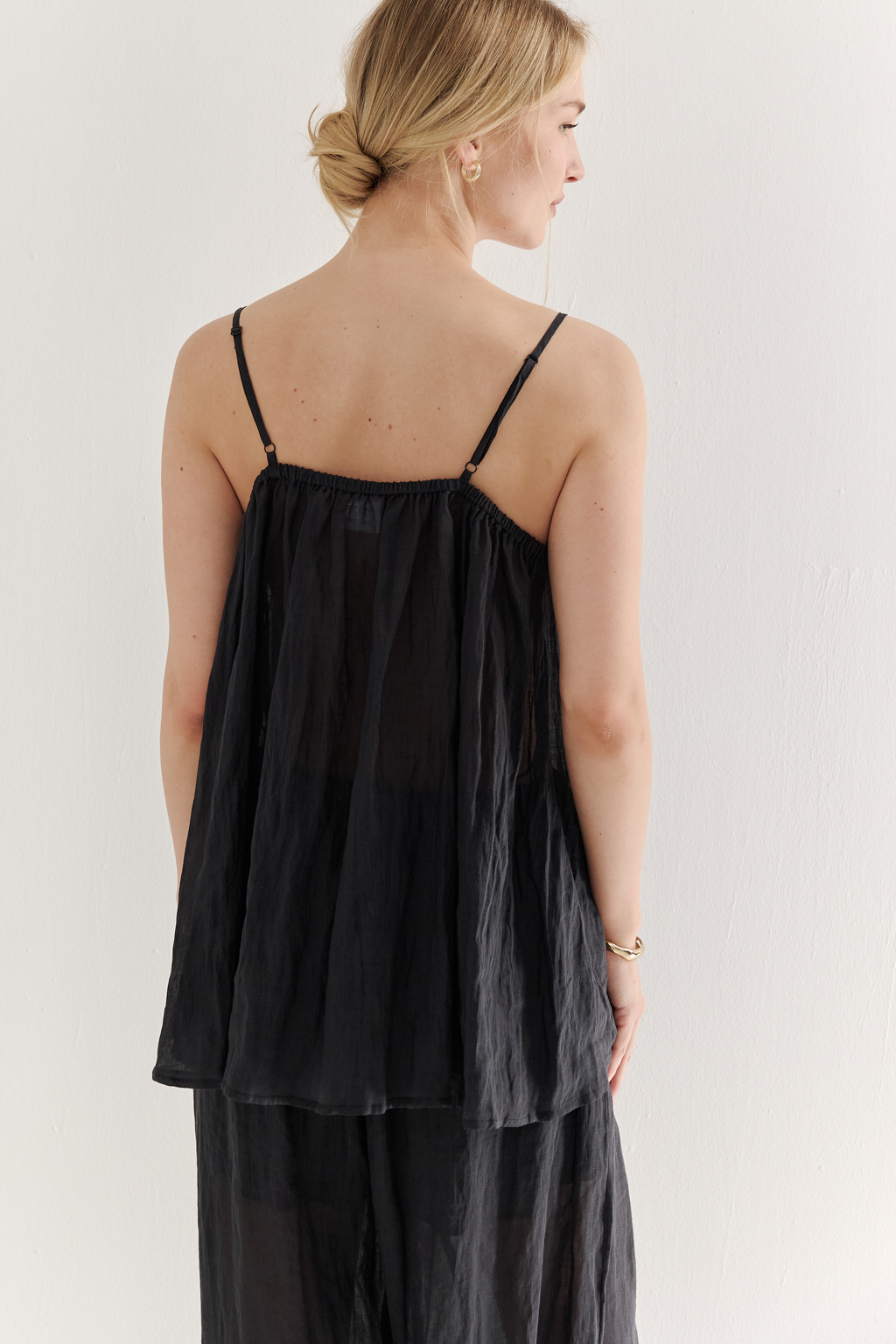 Топ-трапеция, выполненный из стопроцентной крапивы с крэш эффектом в черном цвете, украшен отделкой из кружевного гипюра в тон основной ткани. Кружевная деталь изысканно располагается на передней части изделия. Деталь переда топа настрочены на кружево со сборкой, по верхнему срезу спинки предусмотрена резинка, обеспечивающая оптимальную посадку. Бретели топа регулируются. Топ представляет собой идеальный комплект с брюками из крапивы, льна или хлопка, создавая гармоничный и стильный образ. Хранить в свернутом состоянии.