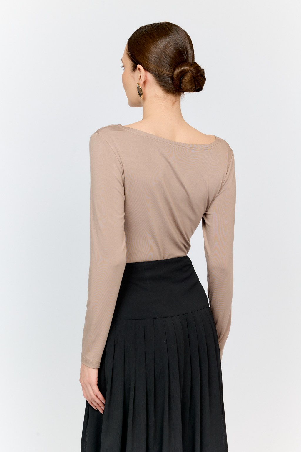 Лонгслив в цветет тофу с глубоким V-образным вырезом горловины и декором из металла в золотом оттенке. Спереди ткань драпируется в области груди и по средней линии полочки. Изделие подарит приятные тактильные ощущения в носке. Подойдет для стилизации со множеством образов.