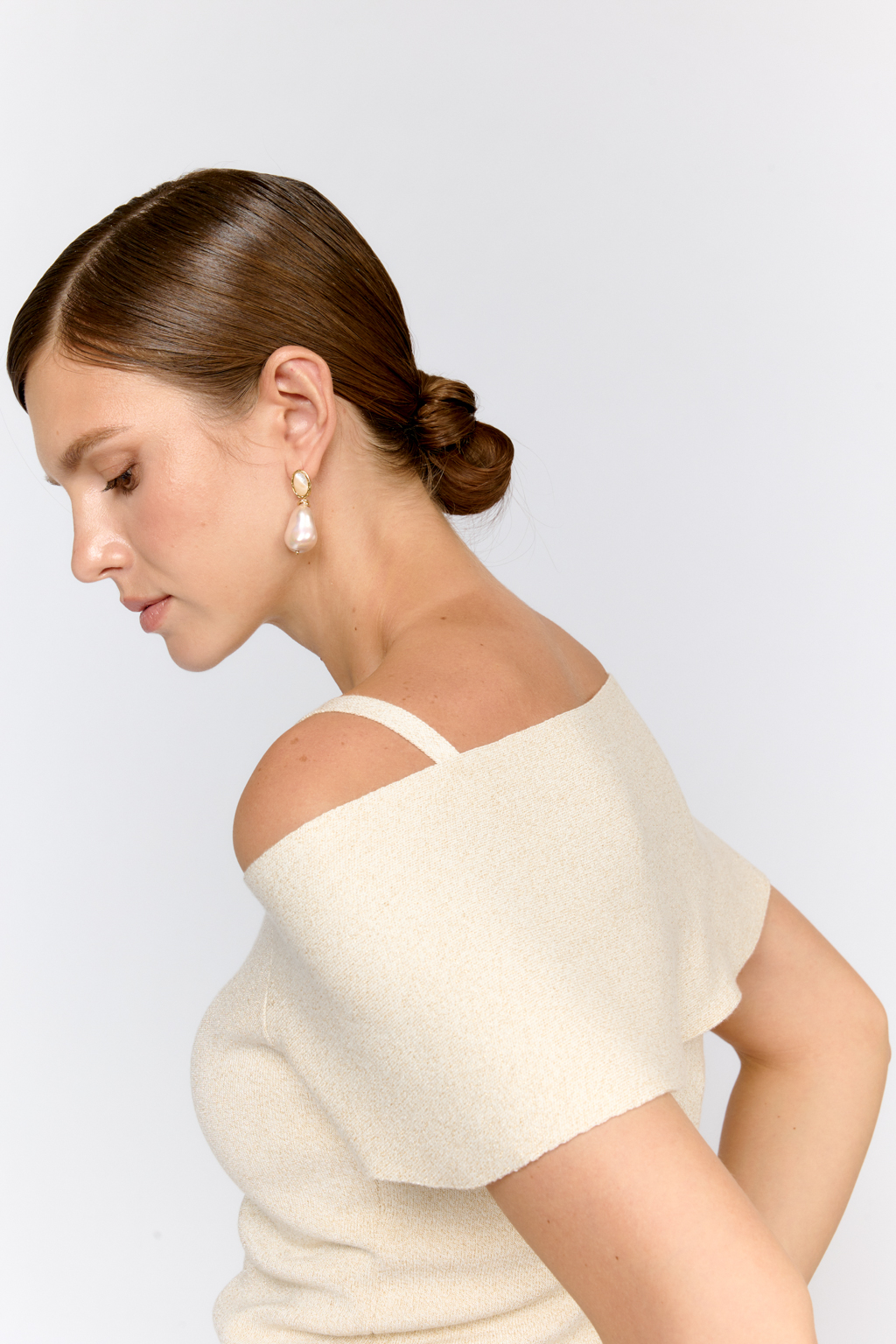 Топ на бретелях с открытыми плечами и пелериной. Оригинальный дизайн модели, подчеркивающий линию декольте и плечи воплощен в приятном к телу материале с вискозой в элегантном молочно-золотом цвете. Топ можно комбинировать с юбкой  или брюками из аналогичного материала. Или сочетать в образах с текстильными брюками из коллекции.