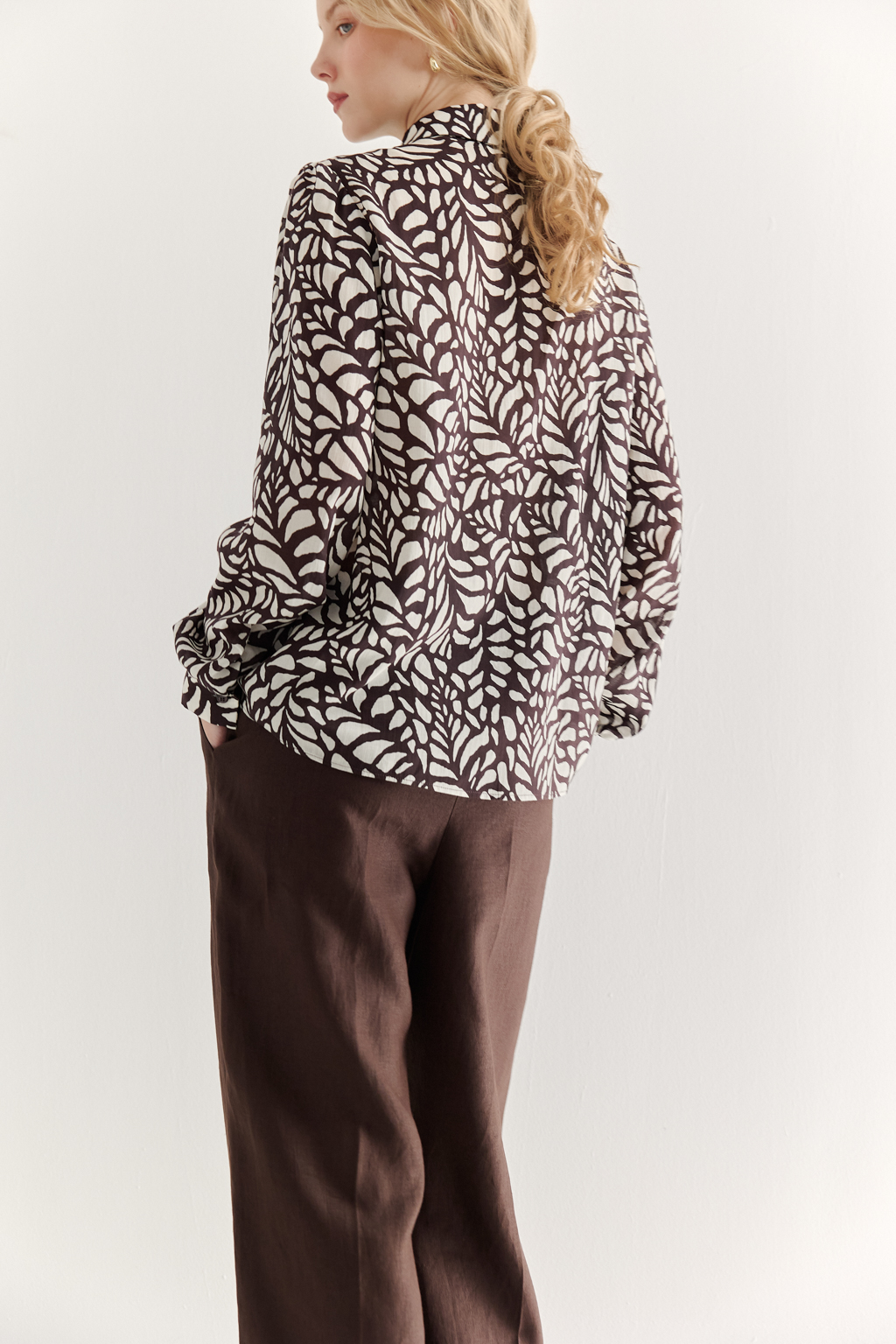 Блуза из легкой блузочной ткани с эффектом шелка со стилизованным растительным принтом в шоколадно-молочной гамме. Комфортная блуза имеет рубашечный воротник со стойкой, длинный рукав с манжетами, застёгивается на пуговицы.