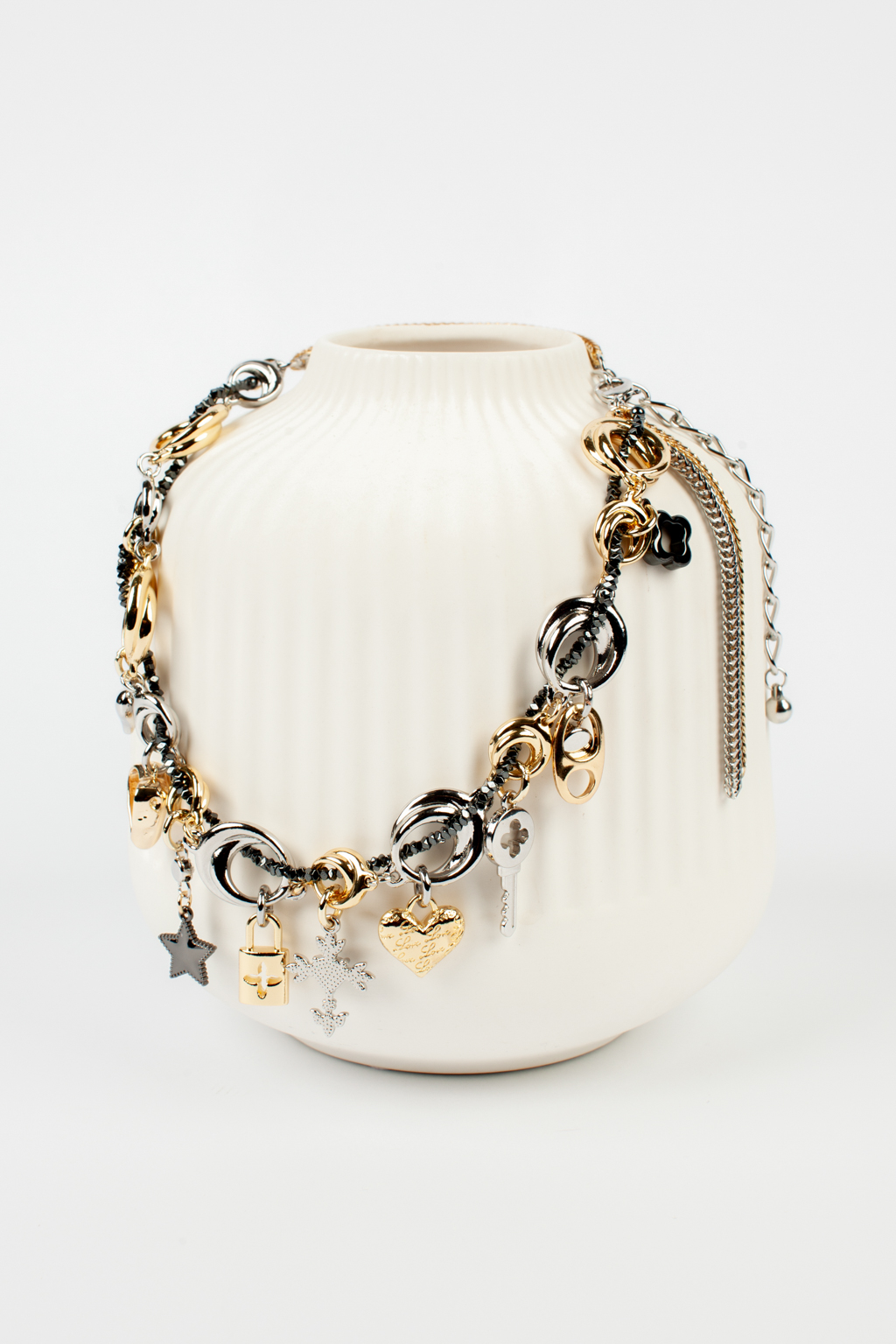 Оригинальное колье на основе металлической цепи с набором необычных подвесок в виде замка, креста, ключа, сердца и звезды. Фурнитура выполнена из гипоаллергенного сплава со стойким гальваническим покрытием золотом и серебром. Длина составляет 45 - 54 см, а вес – 109 гр.