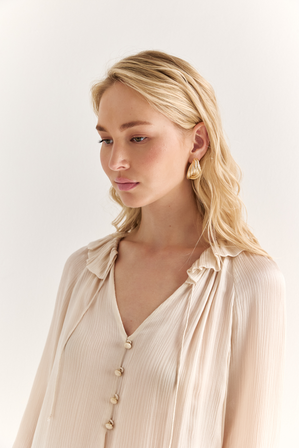 Блуза из 100% шёлка: воздушная элегантность с характером. Эта блуза создана из натурального шёлка — благородной ткани, которая буквально скользит по коже и придаёт образу утончённость. Объёмные рукава с  завязками создают лёгкий силуэт, а мягкая рюша по линии горловины добавляет динамики и изящества. Прямой крой обеспечивает комфорт и универсальность: блуза легко адаптируется под офисный стиль, романтичные образы или вечерние выходы. Носите с классическими брюками, юбками или джинсами — она всегда выглядит достойно. Чистый шёлк. Чистая элегантность.