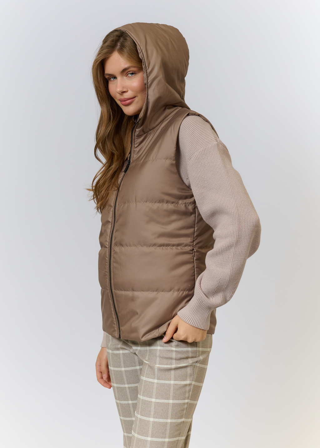 Жилетка на утеплителе с лаконичным капюшоном и молнией. Благодаря силуэту и форме изделие можно носить под пуховиками и тренчем, что создаст актуальный многослойный образ и сохранит тепло в холодную погоду. На подкладке.