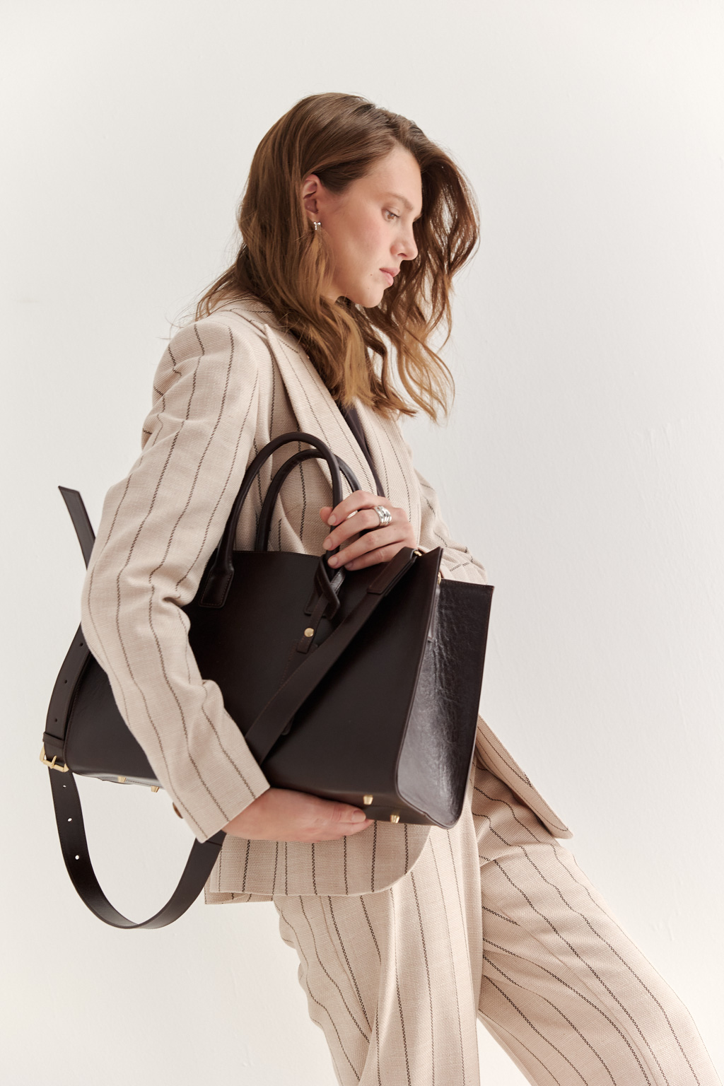 Стильная сумка через плечо глубокого шоколадного оттенка станет незаменимым спутником вашей коллекции. Простая, лаконичная форма идеально впишется в деловой образ. Вместительная модель выполнена из натуральной гладкой кожи с ручками сверху и дополнена ремешком через плечо. Размеры сумки: 39,7*25*14 см.