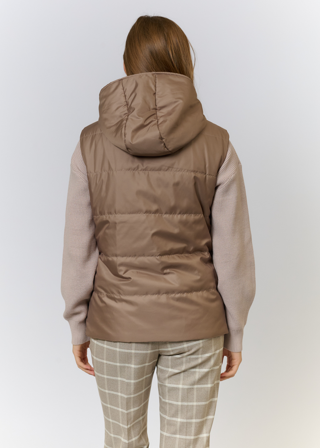 Жилетка на утеплителе с лаконичным капюшоном и молнией. Благодаря силуэту и форме изделие можно носить под пуховиками и тренчем, что создаст актуальный многослойный образ и сохранит тепло в холодную погоду. На подкладке.