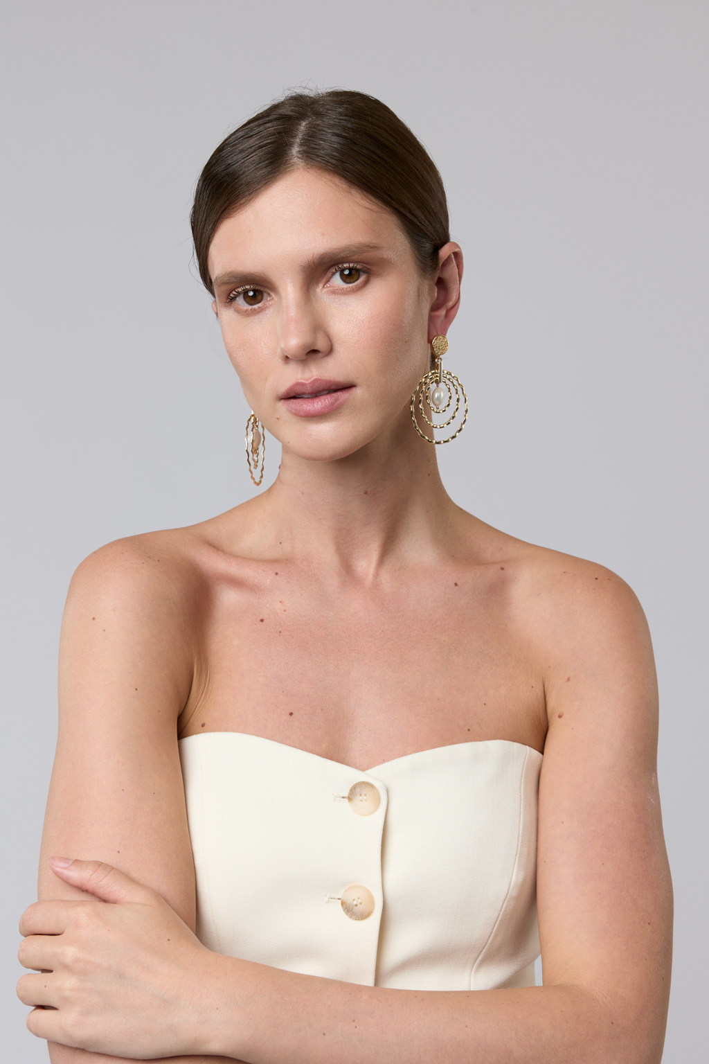 Современные крупные дизайнерские серьги из коллекции "Classic line" выполнены из металла золотого цвета в виде уменьшающихся  колец и центральной подвески из майорки. Свободная закрепка и рифленая фактура создают эффект мерцания при движении. Вес 10 г, длина - 7 см. Украшение выполнено из гипоаллергенного сплава со стойким гальваническим покрытием.