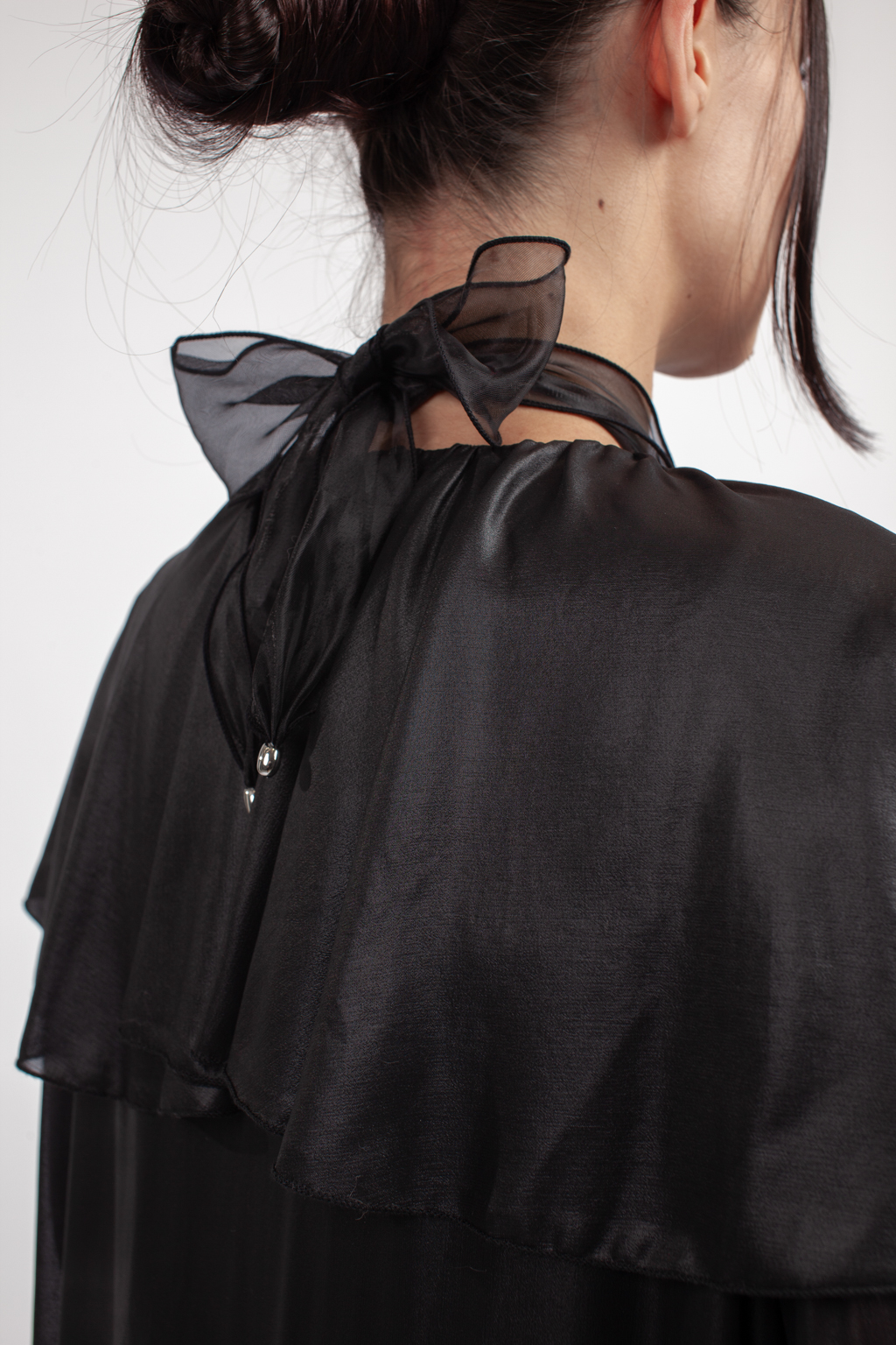 Дизайнерское колье с металлическим кулоном в виде летящей птицы серебряного цвета на текстильной ленте из черной плотной органзы. Длина ленты позволяет варьировать стиль колье. Украшение выполнено из гипоаллергенного сплава с гальваническим покрытием.  Вес колье составляет 39 гр, длина до 140 см.