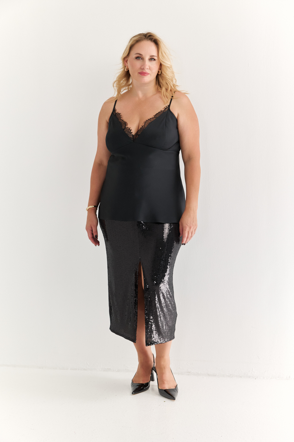 Силуэтная юбка длины миди с разрезом спереди из эластичной ткани с крупными мерцающими пайетками. Полиэстер практичен в уходе, держит форму и устойчив к сминанию. Преимущества ткани: умеренно блестящая, привлекающая  внимание ткань, для создания  эффектных образов. Пайетки придают изделиям уникальный блеск и сияние, делая их запоминающимися и праздничными. Основа  - мягкая пластичная сетка, что делает изделие комфортным.