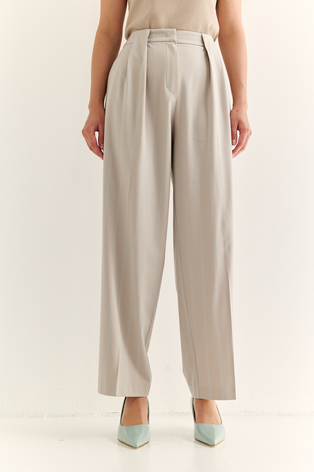 Брюки со складками: актуальный силуэт и комфорт с характером. Эти брюки с высокой посадкой и мягкими складками от талии — отличный баланс между классикой и современностью. Складки добавляют объёма и свободы в движении, формируя красивую линию бедра, а зауженные книзу штанины подчёркивают динамичность образа и визуально стройнят. Прорезные карманы сзади, шлёвки под ремень и точный крой делают модель универсальной: носите с жакетами, блузами или базовыми топами — от офиса до неформальных выходов. Гармония объёма и структуры. Брюки, которые работают на вашу фигуру.