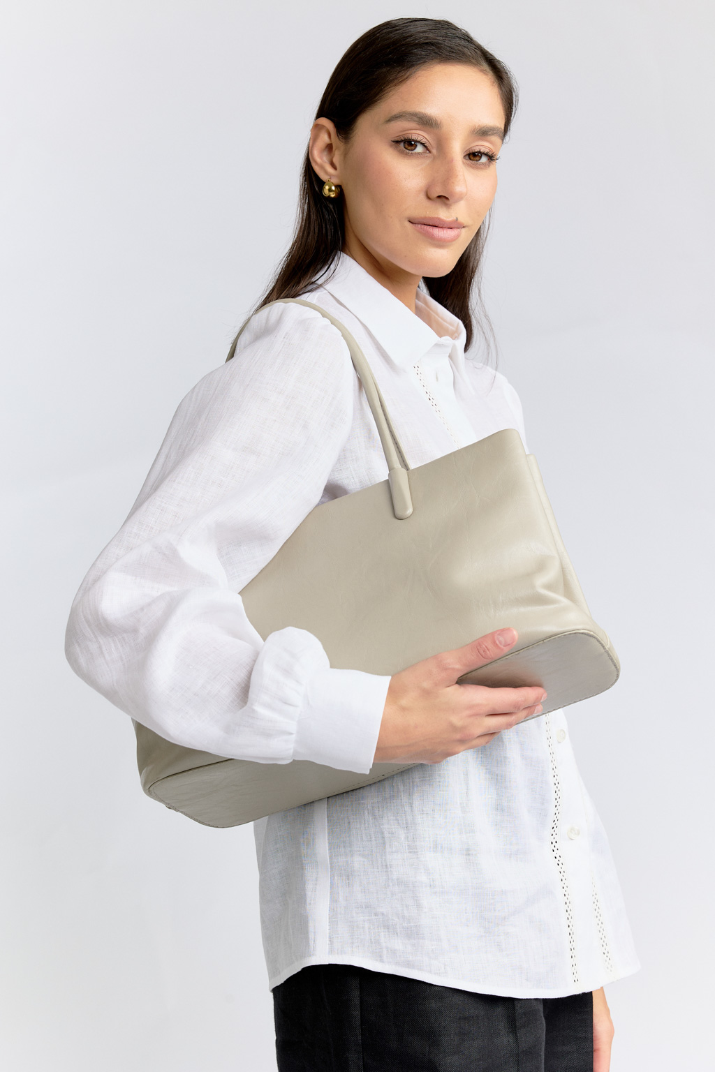 Сумка в нежном серо-бежевом цвете является незаменимым аксессуаром базового гардероба. Аксессуар выполнен из высококачественной мягкой эко-кожи, которая отличается повышенной износостойкостью. Сумка закрывается на металлическую молнию и имеет удобные ручки. В комплекте также есть съемный регулируемый ремешок. Размеры:36x13x20 см