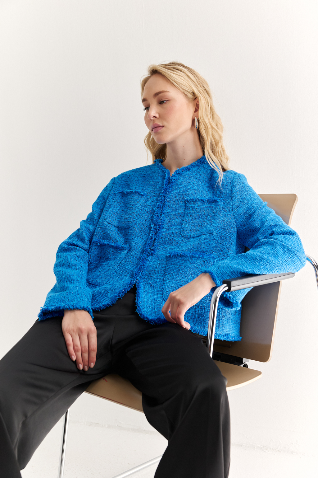 Жакет в стиле Chanel: текстура, изящество, характер
Икона стиля в современной интерпретации — укороченный жакет с застёжкой на крючки и декоративной бахромой по краям. Круглый вырез, слегка расклешенный силуэт и акцентные накладные карманы формируют элегантную геометрию, а текстурная отделка добавляет образу артистичной дерзости.
Эта модель легко становится центральным элементом образа — носите с юбкой, брюками или даже джинсами, создавая контраст между фактурой и формой. Идеальный выбор для женственного, но уверенного стиля.
Современная классика с французским акцентом.