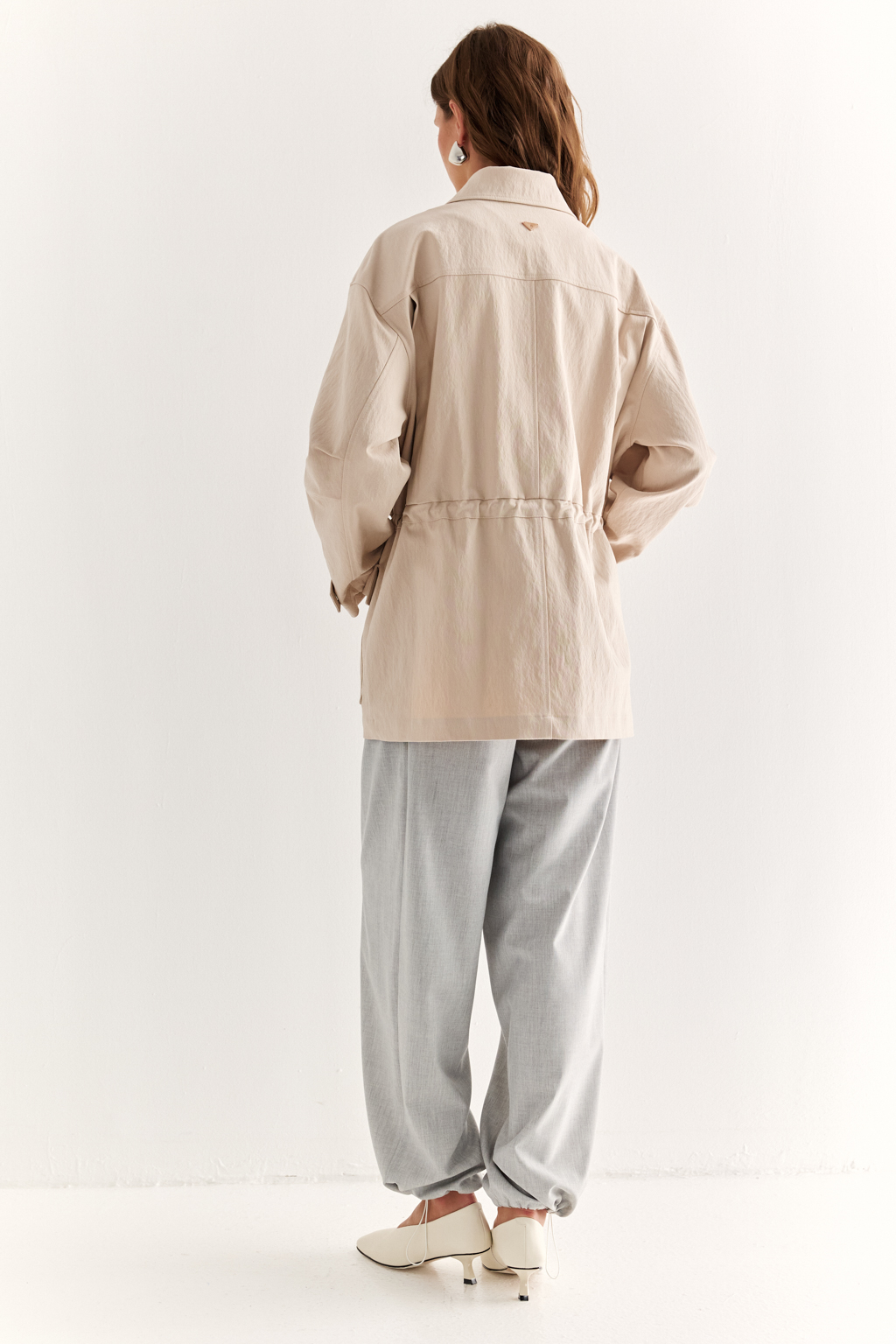 Куртка прямого силуэта длиной до бедер и с кулисой по талии. Воротник рубашечный, застежка под планкой. По полочке накладные карманы-портфели.