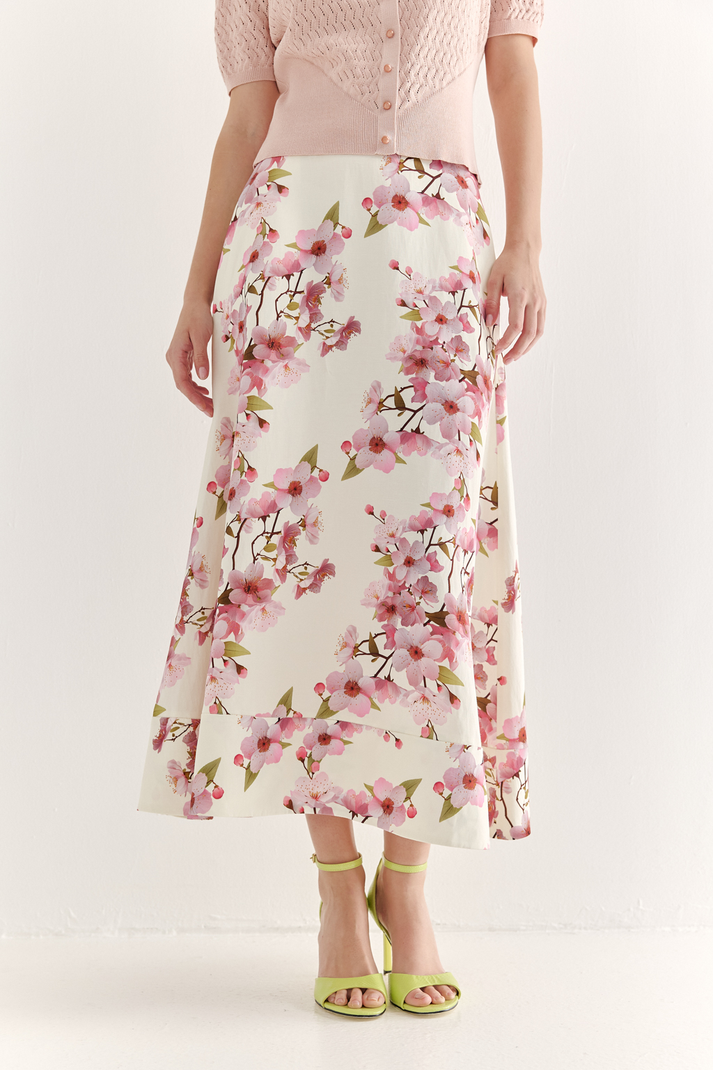 Юбка миди с силуэтом полусолнце, создана из плотной, но при этом пластичной ткани, где основу составляют волокна вискозы и льна. Расширяющийся книзу силуэт дополнен притачным бордюром по нижнему краю, что подчеркивает женственность образа. Ключевой деталью, является эксклюзивный принт, разработанный в дизайн-бюро бренда. В этом принте нежные розовые цветы сакуры и молочный оттенок фона образуют гармоничное, элегантное сочетание, рождающее ощущение красоты и утонченности. Предлагаем носить эту юбку с льняными жакетами в светлых тонах, а так же с корсетом из этой же ткани или вязанными блузами в розовом цвете.