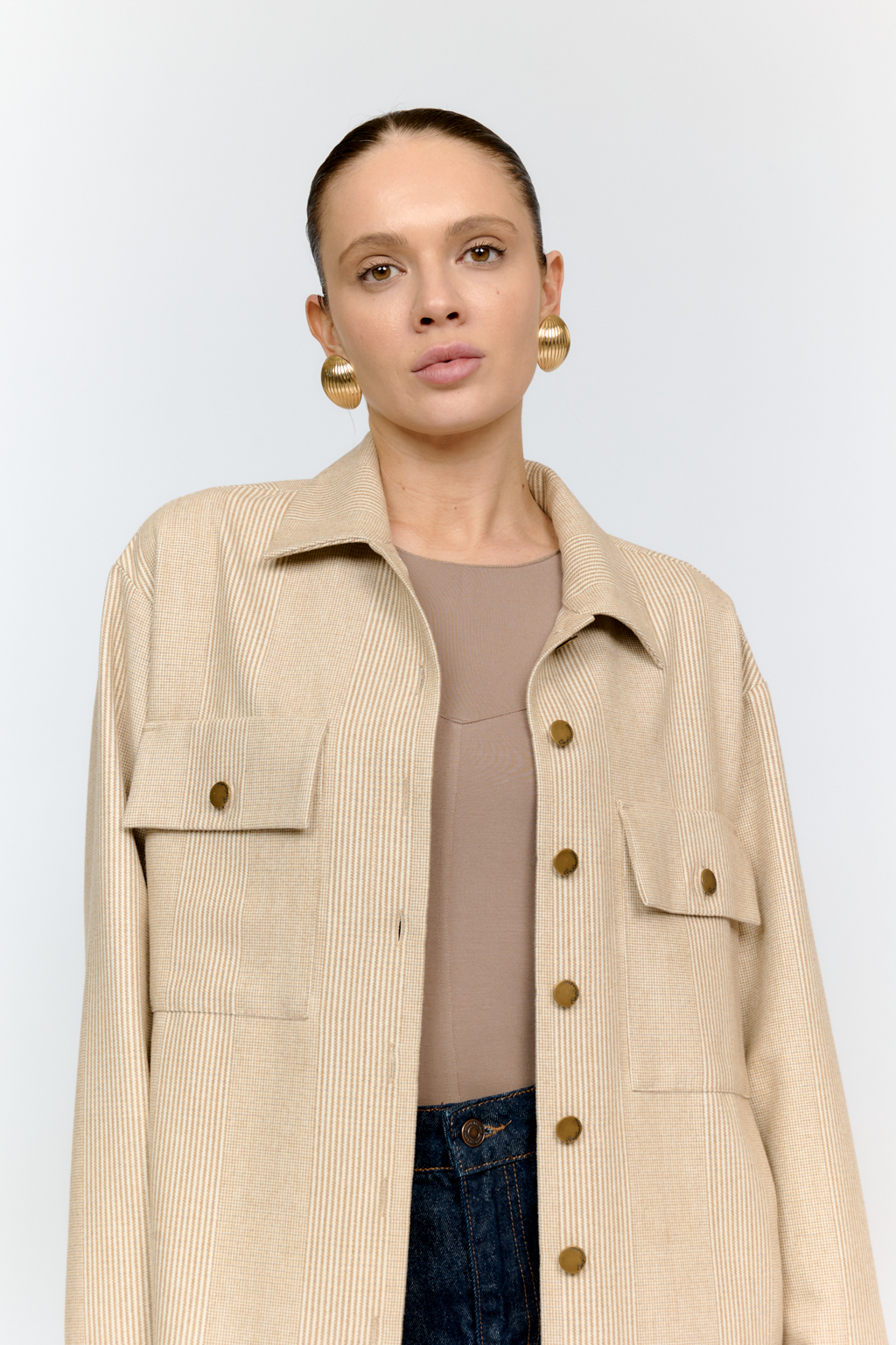 Рубашка свободного кроя с накладными карманами и застежкой на металлические пуговицы-болты из клетчатой костюмной ткани с peach-эффектом идеальна как для многослойных образов с футболками и водолазками, так и в качестве самостоятельной единицы.