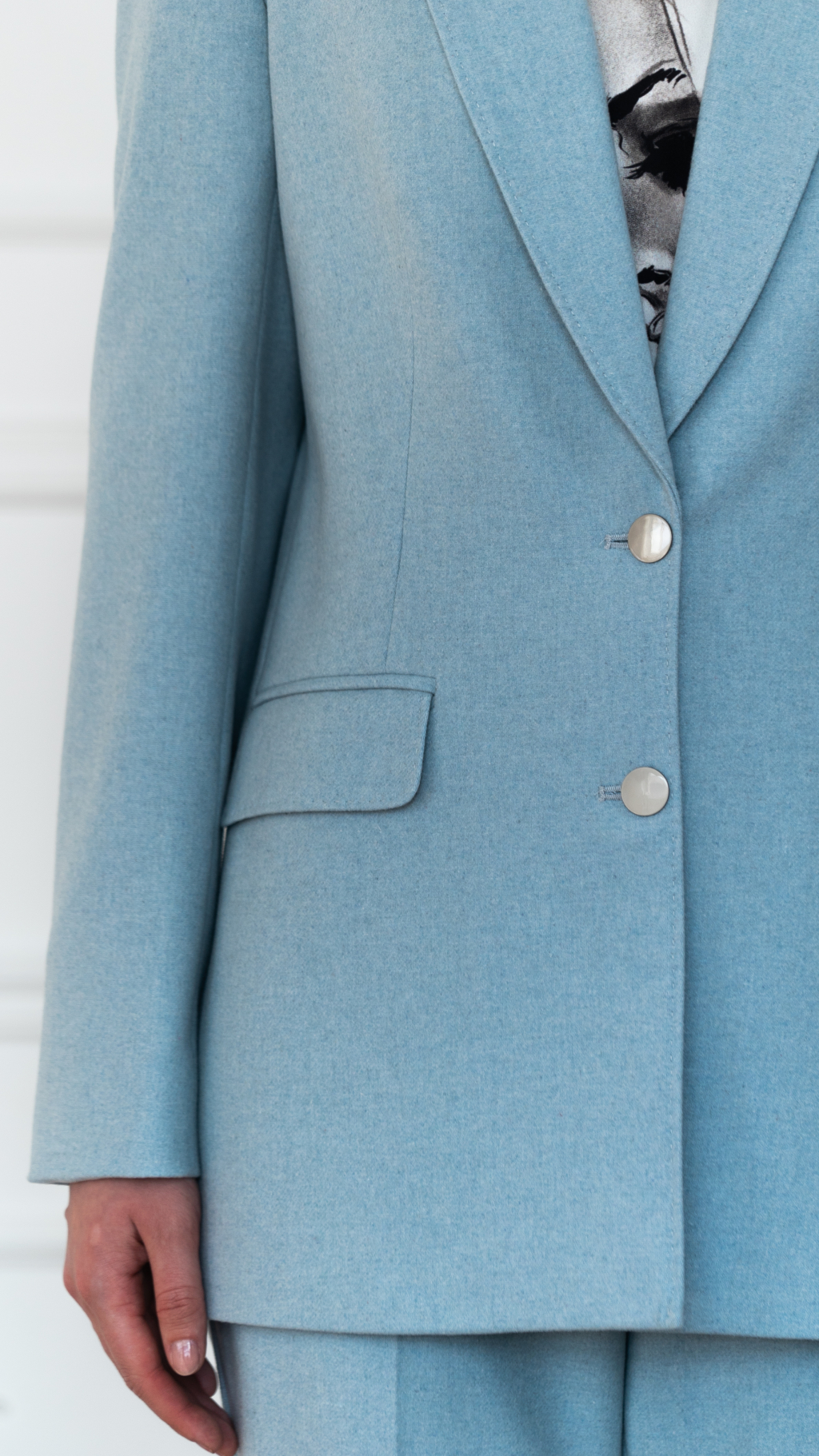 Жакет полуприлегающего силуэта с английским воротником и застежкой на две пуговицы. Длина до бедер. По воротнику декоративная отстрочка "ручной стежок"