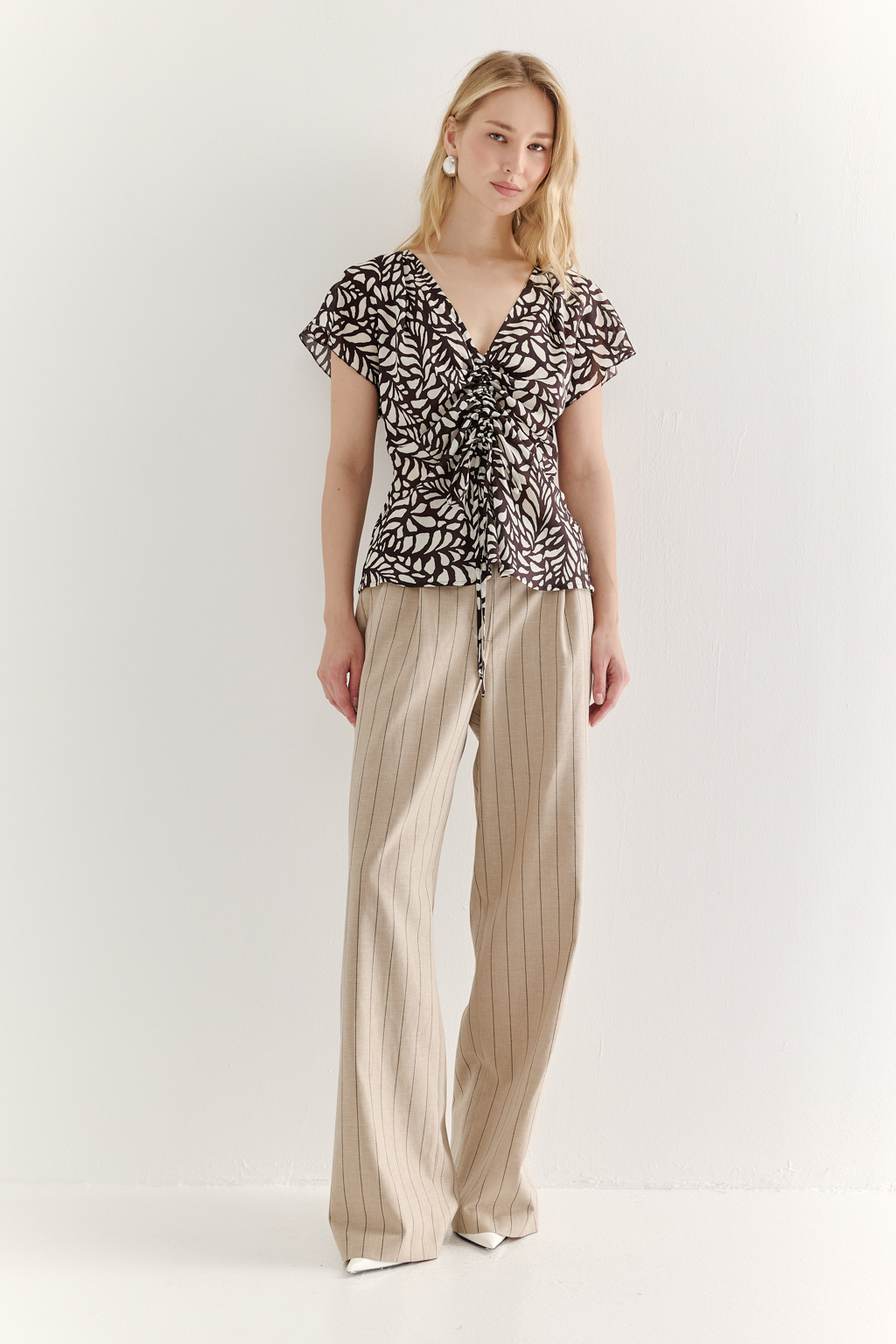 Блуза с драпировкой из легкой блузочной ткани с эффектом шелка со стилизованным растительным принтом в шоколадно-молочной гамме. Цельнокроенный рукав, v-образный вырез, регулируемая драппировка по переду.