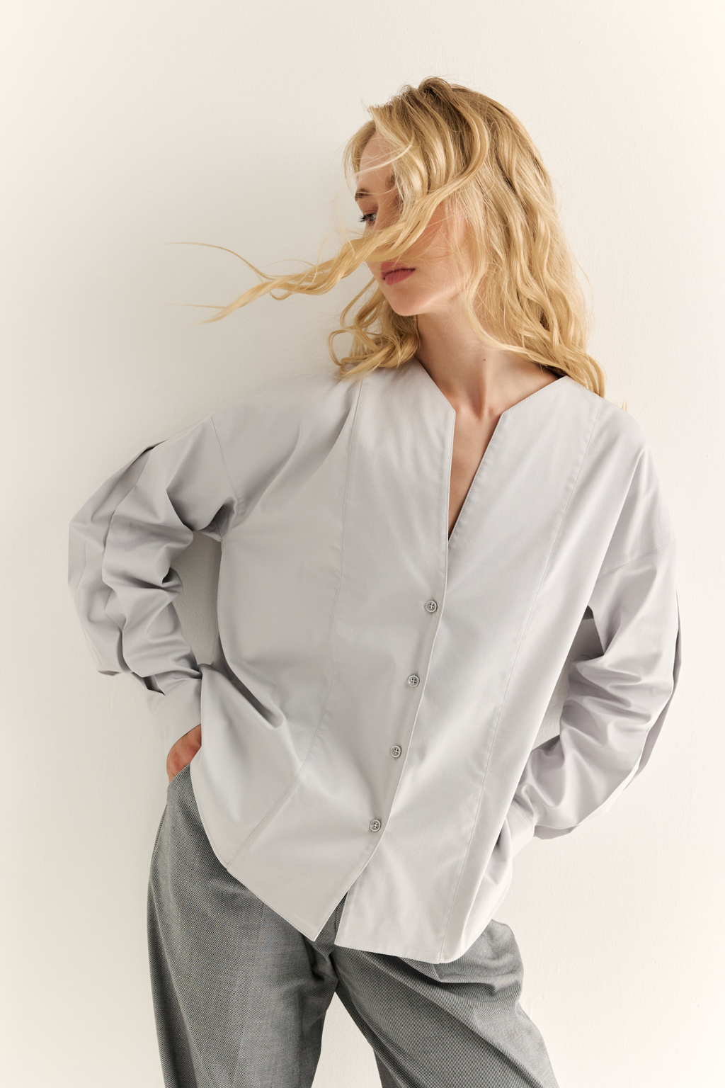 Блуза с V-вырезом: нежность в современном ритме. Эта блуза сочетает в себе деликатность форм и продуманную простоту. Глубокий V-образный вырез визуально вытягивает силуэт, а мягкие линии кокетки и рукавов добавляют романтичности. Объёмные рукава с манжетами и аккуратная застёжка на пуговицы завершают образ с лёгкой винтажной ноткой. Идеально смотрится в паре с юбками на высокой талии, широкими брюками или под жилет. Благодаря универсальному дизайну легко вписывается как в деловой, так и в вечерний гардероб. Лёгкость, которая подчёркивает внутреннюю силу.