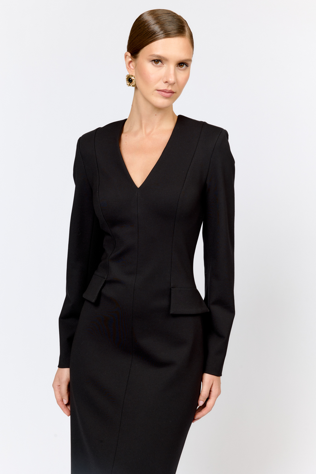 Платье для элегантных образов идеально впишется как в праздничный, так и в будничный гардероб благодаря лаконичности, силуэту и длине. Модель приталенного кроя прилегающего силуэта с глубоким V-образным вырезом и декоративными клапанами создающим эффект баски. Выполнено из плотной трикотажной ткани с содержанием вискозы. Вискоза делает ткань приятной к телу, обеспечивает воздухопроницаемость и пластичность. Нейлон  обеспечивает  износостойкость и стабильность насыщенного цвета.  Преимущества ткани: ткань хорошо держит форму, мягко облегая фигуру.  Не сминается, не требует особого ухода.   Позволяет коже "дышать".