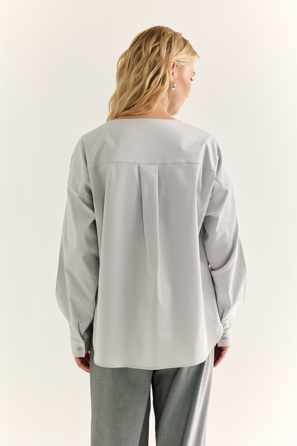 Блуза с V-вырезом: нежность в современном ритме. Эта блуза сочетает в себе деликатность форм и продуманную простоту. Глубокий V-образный вырез визуально вытягивает силуэт, а мягкие линии кокетки и рукавов добавляют романтичности. Объёмные рукава с манжетами и аккуратная застёжка на пуговицы завершают образ с лёгкой винтажной ноткой. Идеально смотрится в паре с юбками на высокой талии, широкими брюками или под жилет. Благодаря универсальному дизайну легко вписывается как в деловой, так и в вечерний гардероб. Лёгкость, которая подчёркивает внутреннюю силу.