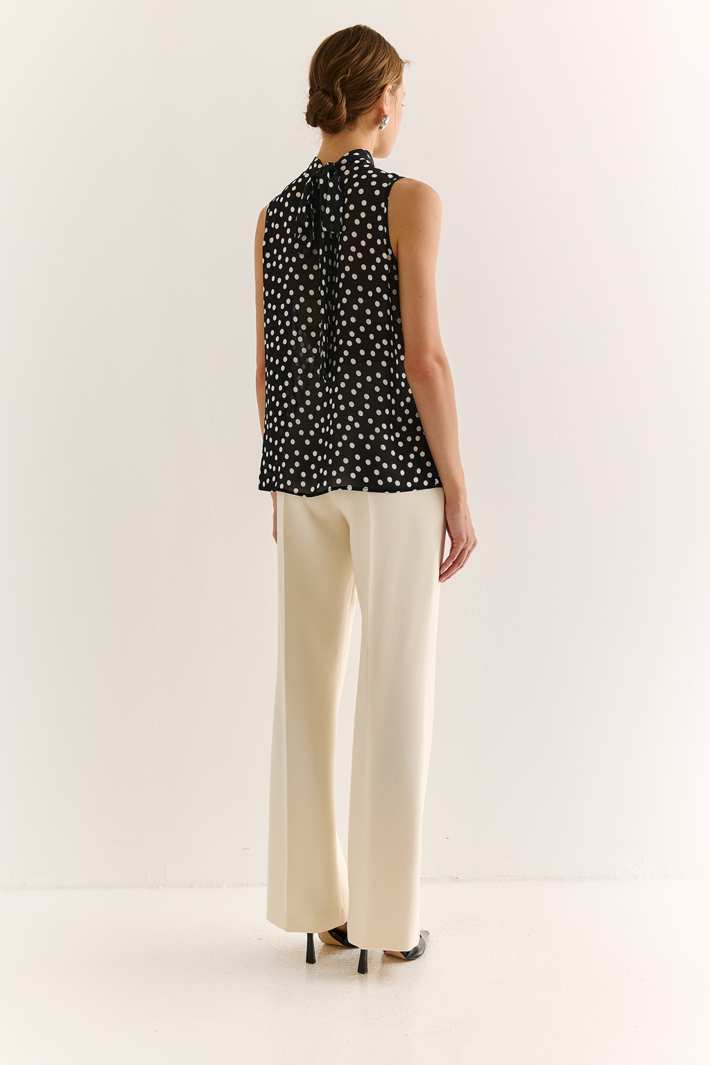 Блузка с бантом: женственность и утончённый акцент. Эта блузка без рукавов — воплощение элегантной простоты с выразительной деталью. Горловина украшена мягким бантом, который добавляет образу нотки утончённости и романтичного шика. Лёгкая драпировка спереди делает силуэт свободным, но изящным, подчёркивая вкус и стиль. Идеальна для офисных будней, деловых встреч или вечерних образов. Эффектно смотрится под жакет или кардиган, но и сама по себе становится акцентом. Сила — в деталях. Женственность — в каждом движении.