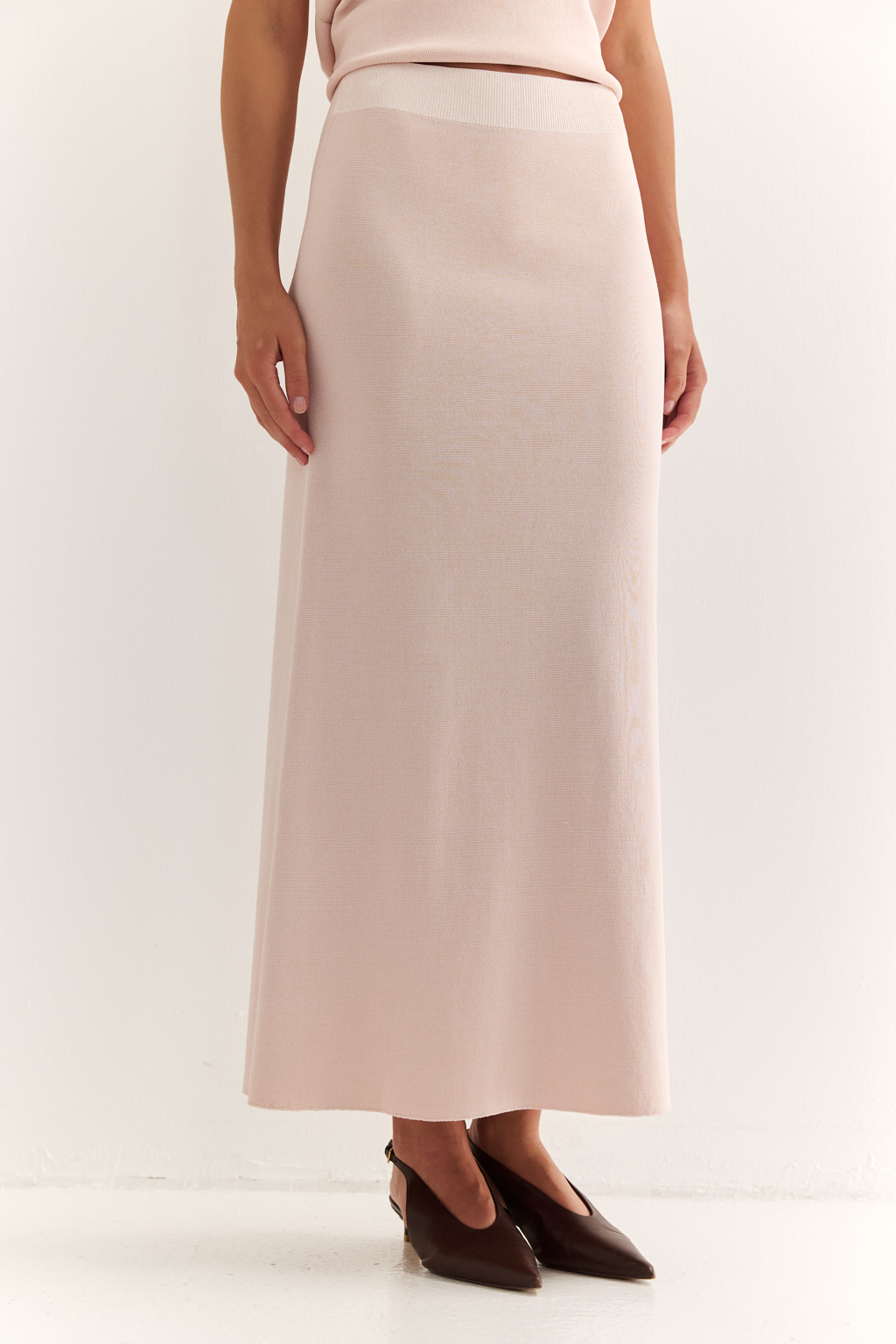 Юбка силуэта трапеции длиной миди.