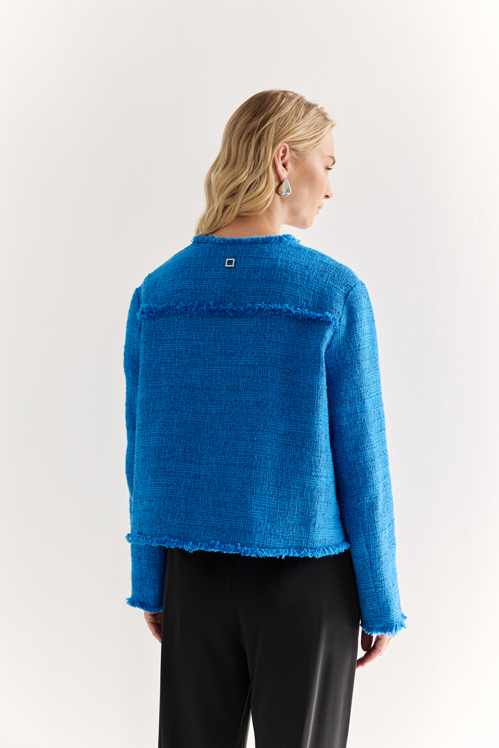 Жакет в стиле Chanel: текстура, изящество, характер
Икона стиля в современной интерпретации — укороченный жакет с застёжкой на крючки и декоративной бахромой по краям. Круглый вырез, слегка расклешенный силуэт и акцентные накладные карманы формируют элегантную геометрию, а текстурная отделка добавляет образу артистичной дерзости.
Эта модель легко становится центральным элементом образа — носите с юбкой, брюками или даже джинсами, создавая контраст между фактурой и формой. Идеальный выбор для женственного, но уверенного стиля.
Современная классика с французским акцентом.