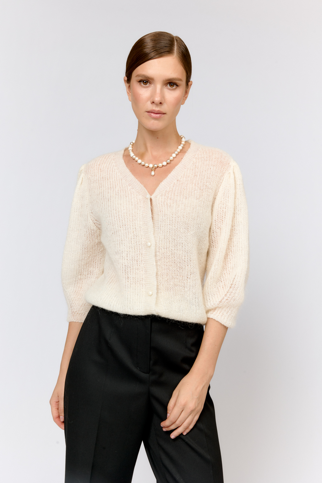 Легкий кардиган с центральной застежкой на пуговицы, V-образной горловиной и укороченным рукавом. Выполнен в премиальной пряже в составе которой, мохер и шерсть. Невесомый на вид, кардиган теплый и уютный. Мохер обладает множеством преимуществ: он легкий, обладает натуральным блеском, прочностью и долговечностью, отлично удерживает тепло. Кроме того, мохер устойчив к скатыванию и деформации. Модель кардигана умеренного объема с укороченным рукавом, идеальна для вечерних образов.