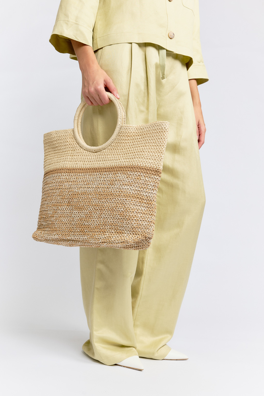 Плетеная сумка из качественной целлюлозы создана для настоящих ценительниц стиля и практичности. Нежная бежево-коричневая расцветка напоминает о легкости пляжной атмосферы. Вместительного размера сумка имеет внутренний кармашек, тканевый подклад и закрывается на кнопку. Круглая ручка обеспечивает комфортное ношение в руке, на запястье или логтевом сгибе. Размеры 30*22*37 см