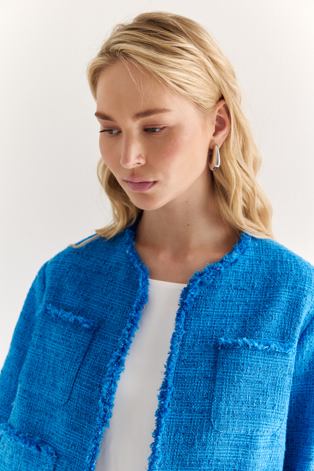 Жакет в стиле Chanel: текстура, изящество, характер
Икона стиля в современной интерпретации — укороченный жакет с застёжкой на крючки и декоративной бахромой по краям. Круглый вырез, слегка расклешенный силуэт и акцентные накладные карманы формируют элегантную геометрию, а текстурная отделка добавляет образу артистичной дерзости.
Эта модель легко становится центральным элементом образа — носите с юбкой, брюками или даже джинсами, создавая контраст между фактурой и формой. Идеальный выбор для женственного, но уверенного стиля.
Современная классика с французским акцентом.