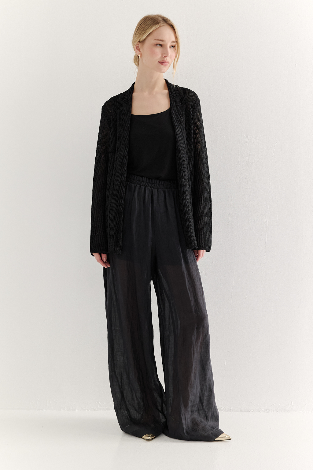 Жакет полуприлегающего силуэта черного цвета из вязаного трикотажа, в составе которого вискоза и хлопок. Плотная скрутка нити образует упругое, но в то же время дышащее полотно. Цельно вязаные лацканы элегантно переходят в воротник, обрамляя вырез. Прямые рукава полной длины завершают лаконичный силуэт. Этот жакет станет изысканным дополнением к непринужденному городскому образу.