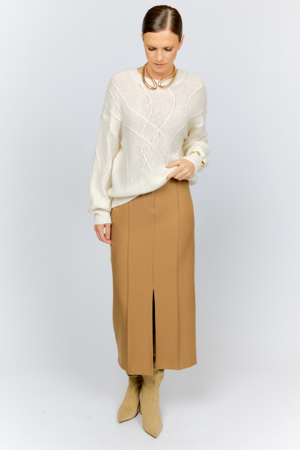 Нежный молочный  джемпер из мягкой шерстяной пряжи с трендовым ажурным дизайном, круглой горловиной, со спущенной линией плеча и длинными рукавами имеет  свободный силуэт оверсайз. Уникальный узор привлекает внимание и придает образу стильный акцент.