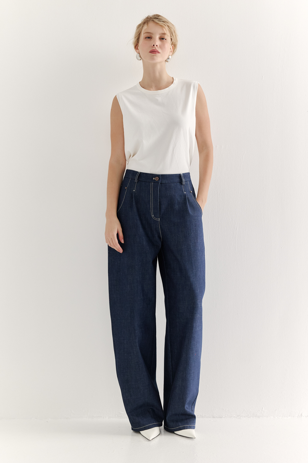 Топ-майка из хлопкового трикотажа молочного цвета в монохромном решении, горловина и проймы обработаны основным материалом.