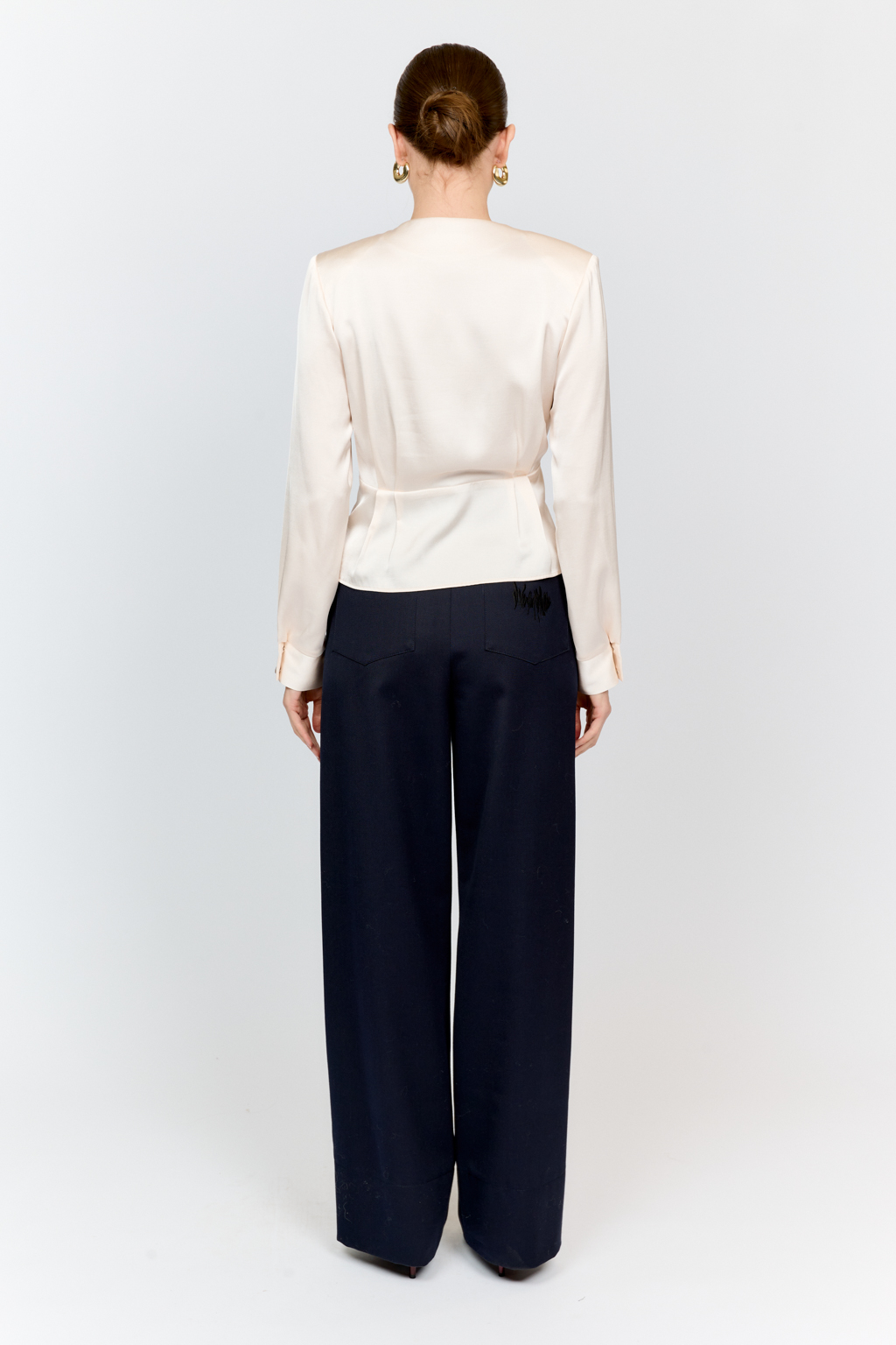 Блуза с глубоким V-образным вырезом горловины и фигурным резом по линией груди, на которой заложены глубокие складки из вискозы с атласной фактурой.