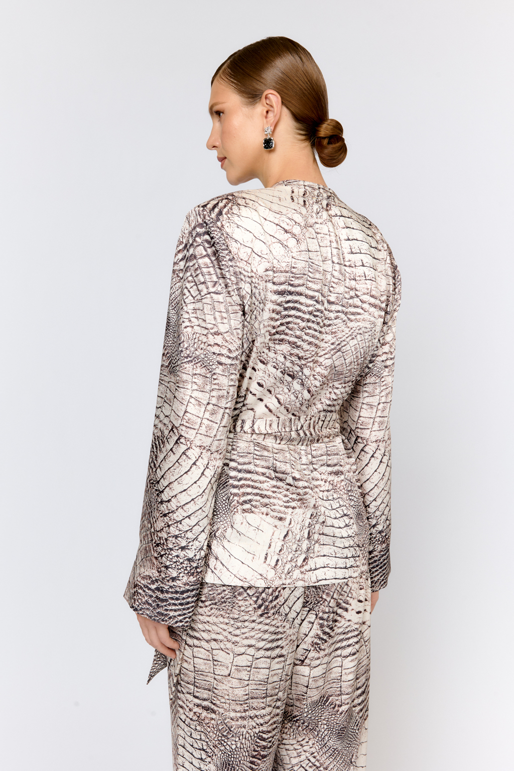 Жакет на запах с завязкой на пояс по талии со складками из струящейся ткани с атласной фактурой и невероятной приятной тактильностью. Вырез горловины глубокий V-образный. Жакет свободного кроя, без подклада для комфортных и праздничных образов в пижамном стиле с брюками в той же ткани из коллекции, а также можно создавать образы, используя модель в качестве блузы с джинсами, брюками, юбками. Преимущества ткани: полиэстер добавляет прочности и практичности, сохраняя форму изделия. Ткань мягко драпируется, легкая и приятная на ощупь. Цветовое сочетание в дизайне принта позволяет комбинировать изделие с другими моделями коллекции.