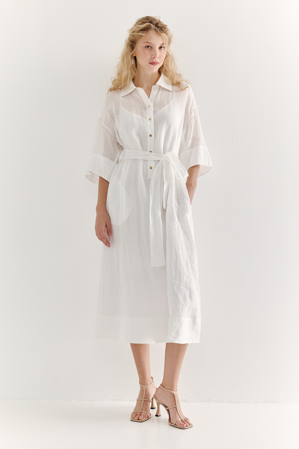 Это комфортное платье – традиционный образ для жаркого летнего дня. Платье изготовлено из воздушной невесомой вуали молочного цвета, в составе которой комфортный и экологичный материал крапива. Отложной воротник, планка для застежки, кокетка спинки, втачной широкий рукав одна вторая с отворотом, притачной бордюр по низу платья, пояс-самовяз и трапецивидный силуэт создают максимально комфортное образ. Возможно создание естственного крэш-эффекта, платье не требует сложного ухода.