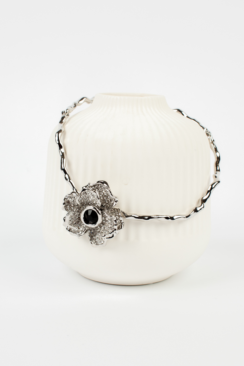 Колье обруч с подвижными частями основы и центральным элементом объёмным цветком инкрустированным сверкающими цирконами. Вся фурнитура колье выполнена из гипоаллергенного сплава со стойким гальваническим покрытием серебром.