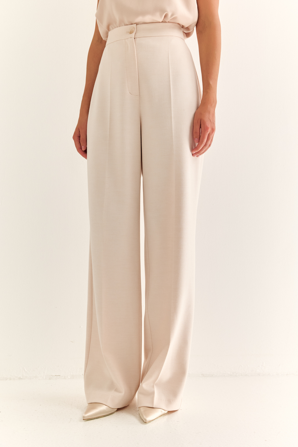Классические брюки: основа безупречного гардероба. Прямые брюки с высокой посадкой и чёткими стрелками — это универсальный силуэт, который подчеркивает достоинства фигуры и вытягивает силуэт. Анатомичный пояс и лаконичные боковые карманы обеспечивают комфорт и чистоту линий, а гладкая спинка делает модель ещё более элегантной. Подходят для делового комплекта с жакетом, а также легко адаптируются в повседневный гардероб с рубашкой, топом или трикотажем. Брюки, которые не требуют усилий, чтобы выглядеть стильно. Форма, проверенная временем. Актуальность — в деталях.