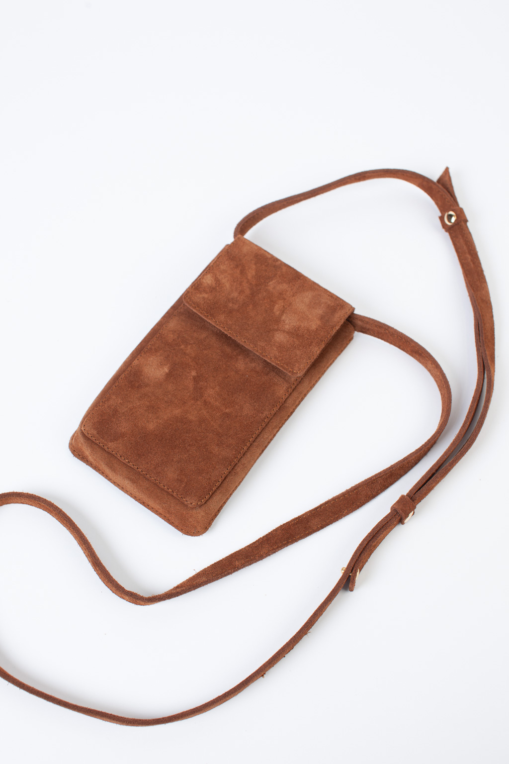 Стильный аксессуар из натуральной замши надёжно защитит Ваш гаджет от ударов и других внешних воздействий. Оснащена основным отделением для смартфона и разнообразных мелочей, а также двумя карманами для банковских карт и визиток. Сумка имеет регулируемый ремешок. Размеры: 17,5*10,3 см