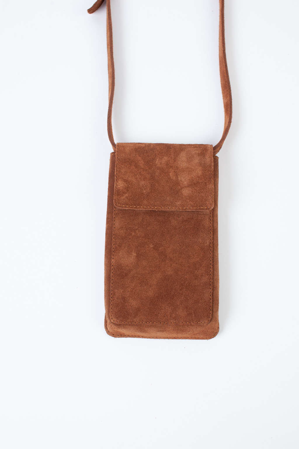 Стильный аксессуар из натуральной замши надёжно защитит Ваш гаджет от ударов и других внешних воздействий. Оснащена основным отделением для смартфона и разнообразных мелочей, а также двумя карманами для банковских карт и визиток. Сумка имеет регулируемый ремешок. Размеры: 17,5*10,3 см