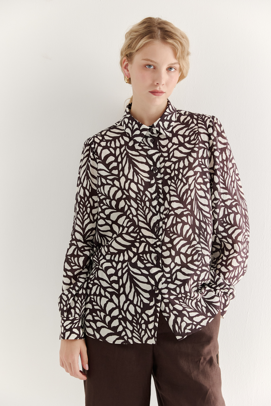 Блуза из легкой блузочной ткани с эффектом шелка со стилизованным растительным принтом в шоколадно-молочной гамме. Комфортная блуза имеет рубашечный воротник со стойкой, длинный рукав с манжетами, застёгивается на пуговицы.