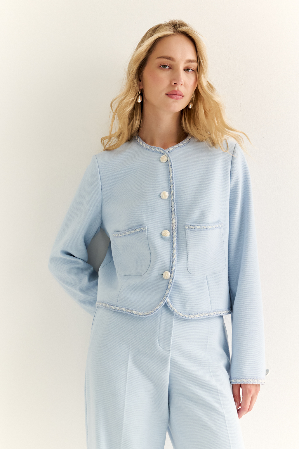 Жакет в стиле Chanel: вечная классика с характером. Икона женственности в новом прочтении — жакет в стиле Chanel с характерными элементами: округлым вырезом, выразительной декоративной тесьмой и крупными акцентными пуговицами. Прямой укороченный силуэт подчёркивает линию талии и делает модель идеальной как для офисного образа, так и для изысканного вечера. Накладные карманы добавляют практичности и шарма, а отделка по борту и рукавам формирует изящную рамку силуэта. Носите с юбкой, джинсами или брюками — он добавит статусности в любой комплект. Легендарный силуэт. Современное звучание.