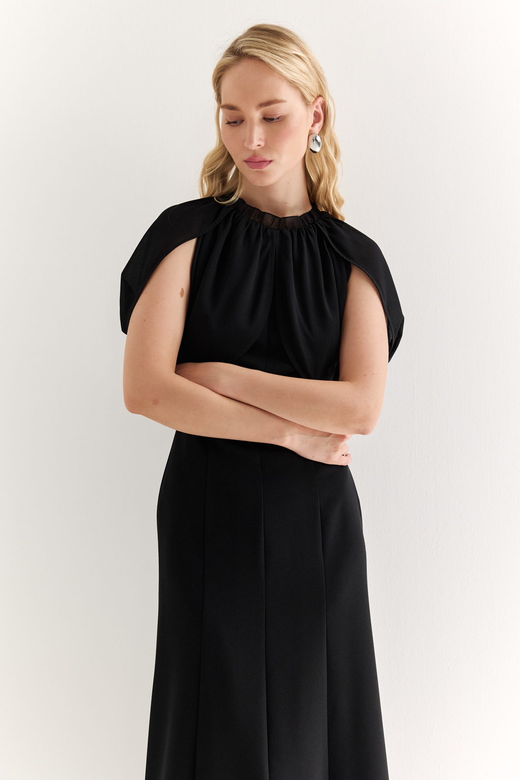 Платье с эффектом лепестков и шифоновой драпировкой: утончённая женственность в движении

Это платье словно создано для того, чтобы подчеркнуть красоту силуэта и придать образу воздушности. Драпировка на плечах из полупрозрачного шифона формирует эффект лепестков, мягко окутывая верх и придавая образу лёгкость, загадочность и изысканность.

Приталенный крой с расклешённой нижней частью визуально вытягивает фигуру и подчёркивает талию. Шифон не только добавляет деликатной динамики, но и создаёт выразительный контраст с плотной основной тканью, подчеркивая архитектуру платья.

Идеально подойдёт для вечерних выходов, приёмов и особых событий, где важна не только элегантность, но и уникальность подачи.

Воздушная графика. Платье, в котором ткань говорит языком чувственности.