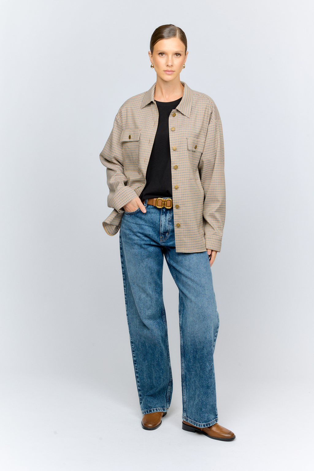 Рубашка свободного кроя с накладными карманами и застежкой на металлические пуговицы-болты из клетчатой костюмной ткани идеальна как для многослойных образов с футболками и водолазками, так и в качестве самостоятельной единицы.